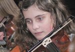Členka dětského symfonického orchestru hrající na housle